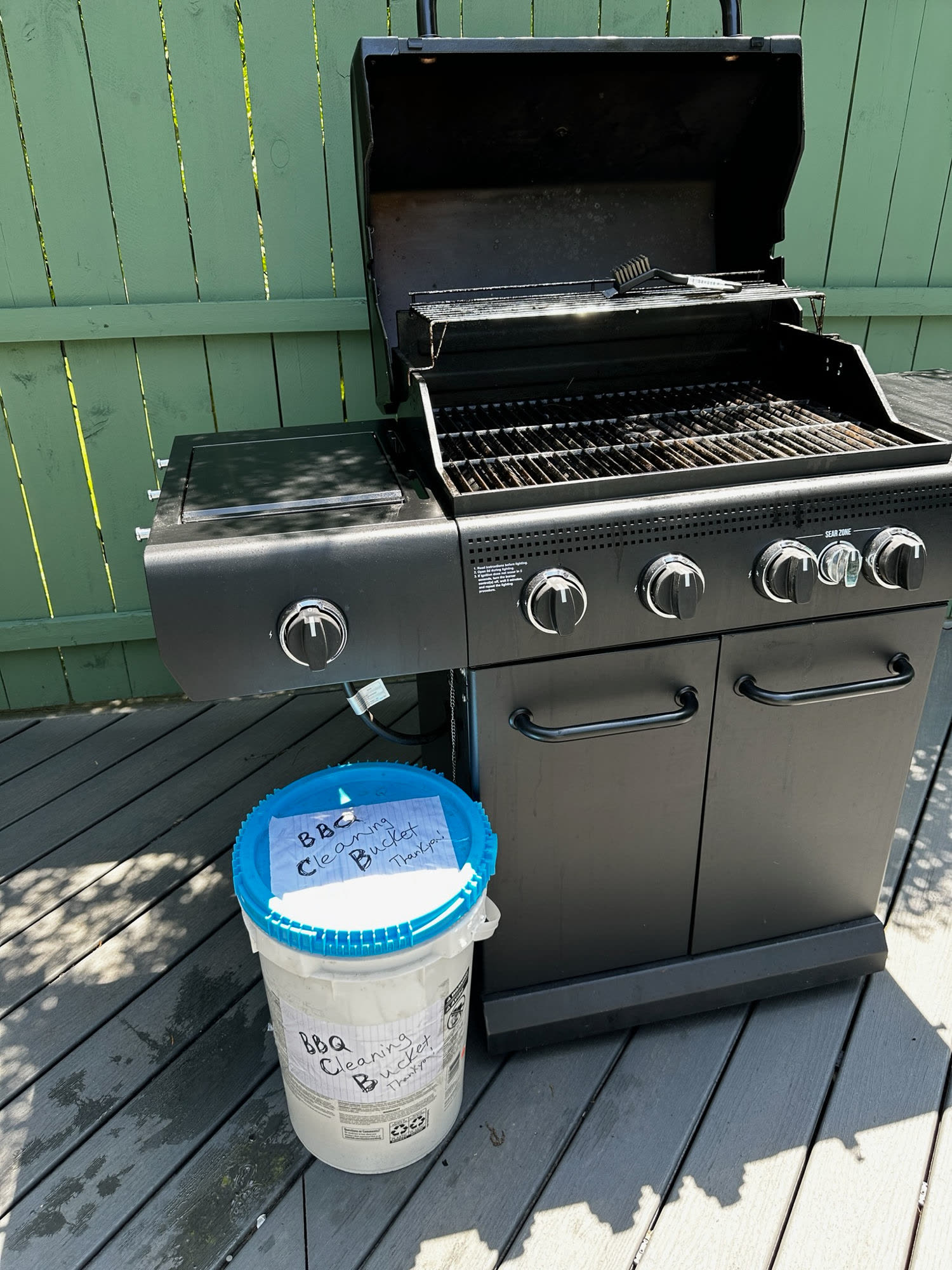 Grill and blue-lidded BBQ Cleaning Bucket